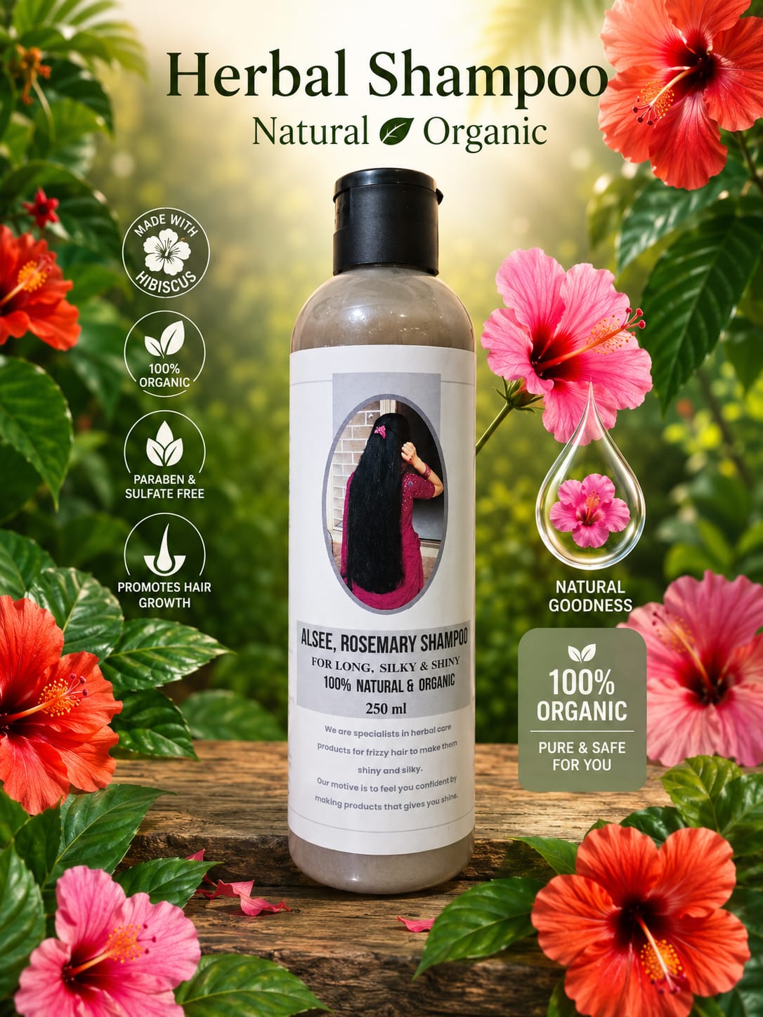 A bottle of herbal shampoo centered on a rustic wooden surface, surrounded by bright hibiscus flowers and green leaves. The label reads 'Aloe, Rosemary Shampoo' 

